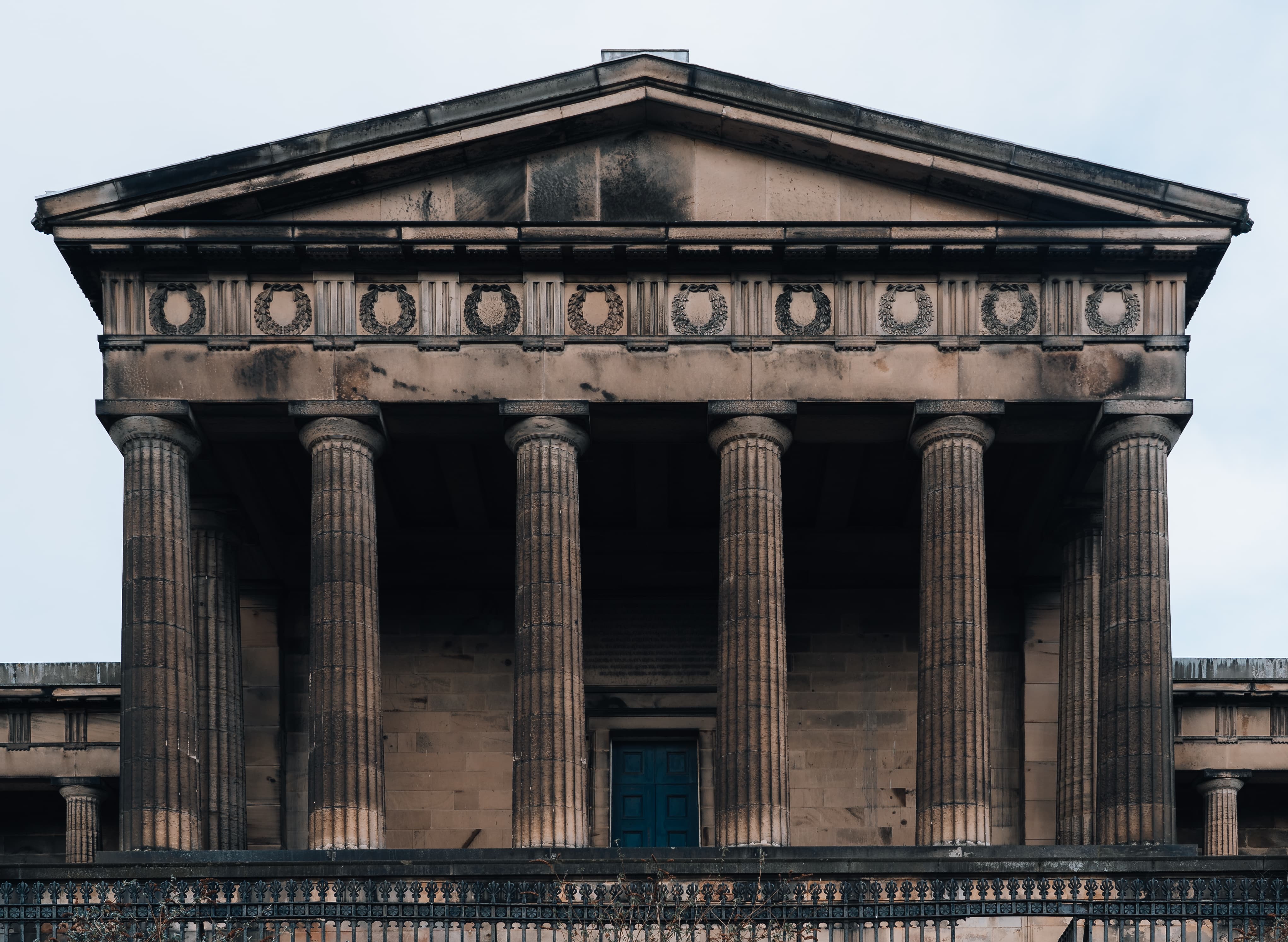 External image of building with pillars and a blue door